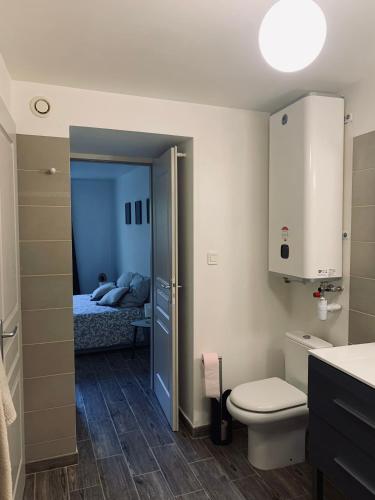 - une salle de bains avec toilettes et un lit dans une chambre dans l'établissement L'évasion and work, au Thor