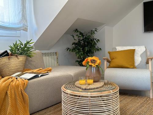 a living room with a couch and a table with glasses of orange juice at Ático Luz y Mar in Cambados