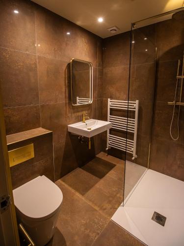 a bathroom with a toilet and a sink and a shower at Fellpack House in Keswick