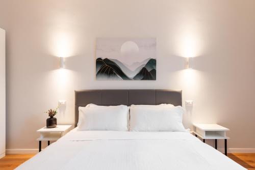 a bedroom with a large white bed with two tables at Major House - Luxury Apartments in Rome by Hostand in Rome