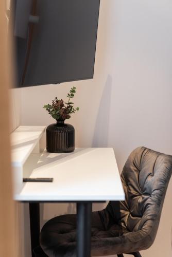 a white table and a chair with a plant on it at Major House - Luxury Apartments in Rome by Hostand in Rome