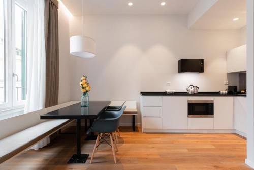 a kitchen and dining room with a black table and chairs at Major House - Luxury Apartments in Rome by Hostand in Rome