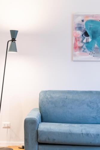 a blue couch in a living room with a lamp at Major House - Luxury Apartments in Rome by Hostand in Rome