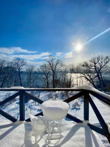 a white table and chair in the snow at The Lobs, Lake Toya "former Yellow House by Lake Toya" in Tōya
