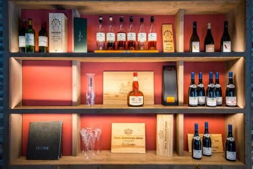 a shelf filled with bottles of wine and books at Hotel Le Samoyede in Morzine