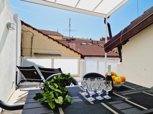 una mesa con copas de vino y verduras en el balcón en HomeHoliday LUXE - MY PLACE SANREMO, en San Remo