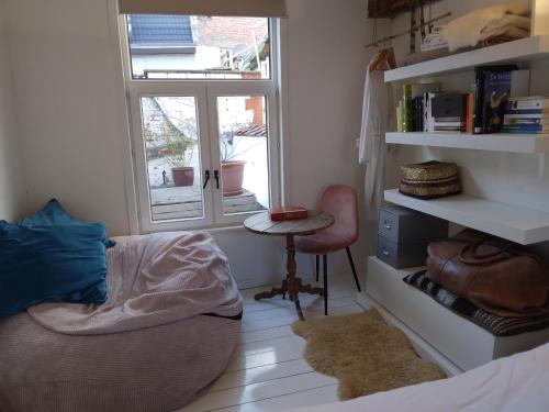 Schlafzimmer mit einem Bett, einem Schreibtisch und einem Fenster in der Unterkunft Smiling Fox Room in Löwen