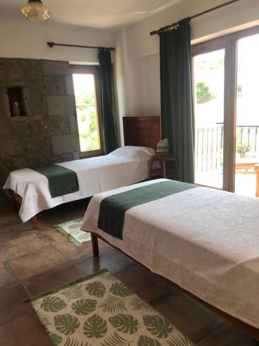 1 dormitorio con 2 camas y ventana en Pırnal Köy Evi, en Ayvacık
