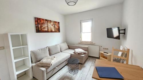 a living room with a couch and a table at FeelGood Ferienwohnung in Schweina