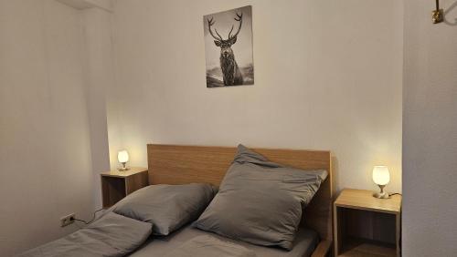 1 cama con 2 almohadas y una foto de un ciervo en FeelGood Ferienwohnung, en Schweina