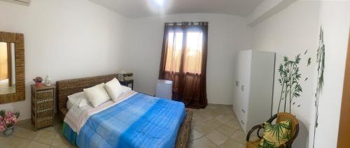 a bedroom with a bed with a blue blanket at Bacio di sole Apartment and rooms in Pula