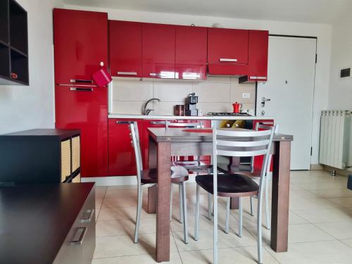 a kitchen with red cabinets and a bar with stools at La casa di Laura in Seregno
