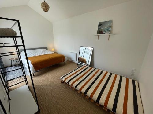een slaapkamer met een stapelbed en een stapelbed bij Maison 4 chambres - 8/10 personnes, proche mer in Brem-Sur-Mer