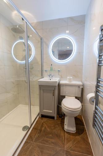 a bathroom with a toilet and a sink and a shower at The Resolution Hotel in Whitby