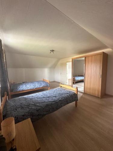um quarto com 2 camas e piso em madeira em THE 11 gîte pour vacances ou travail em Comines