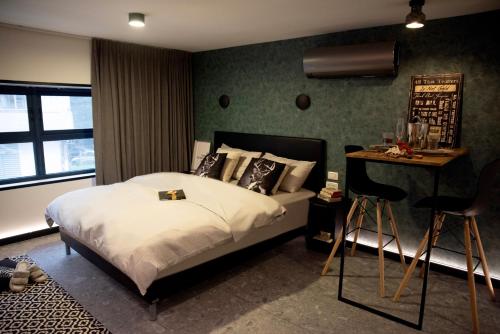 a bedroom with a bed and a table and chairs at Urbano in Haifa