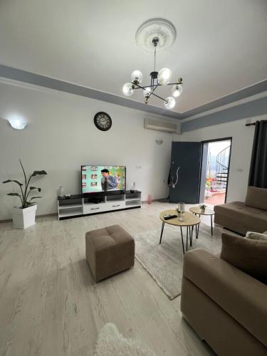 a living room with a couch and a tv at Himalayas in Gjirokastër