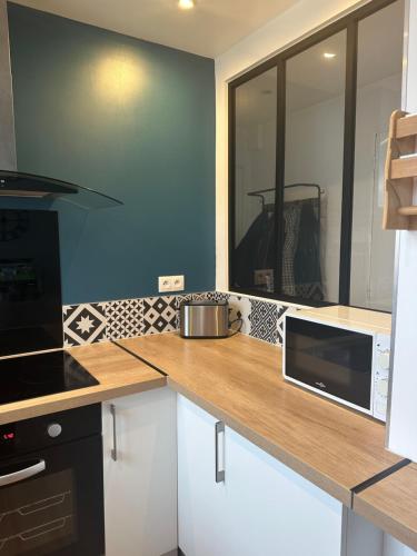 - une cuisine avec un comptoir en bois et un four micro-ondes dans l'établissement Appartement 40m2 Caen, à Caen