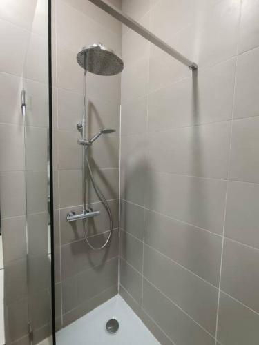 une douche avec une porte vitrée dans une salle de bain dans l'établissement Appartement quartier Chartrons étage 1, à Bordeaux