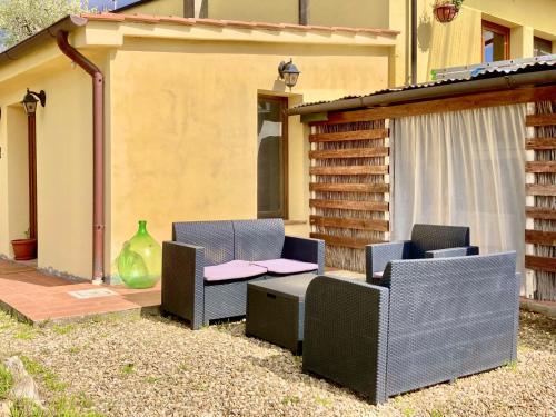 a patio with two chairs and a table at Poderino di Santa Lucia in Villa Nagliati