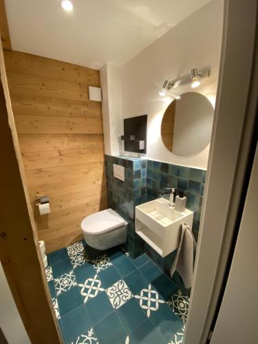 uma casa de banho com um WC branco e um lavatório. em Chalet L'Adret, 3,5 pièces dans les combles. em Gryon