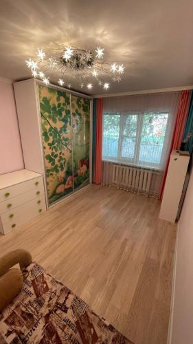 ein Zimmer mit einem Bett und einem Gemälde an der Wand in der Unterkunft Квартира между правым и левым берегом, рядом с набережной на улице Габдуллина in Astana