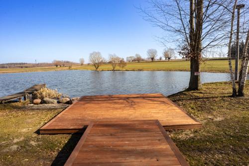 a wooden dock sitting on the side of a lake at Osada Mazurowe Love in Miłakowo