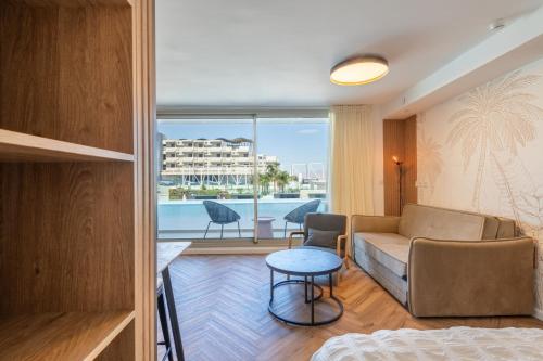 a living room with a couch and a table at Sea View Coral - City Center Amazing Pool in Eilat