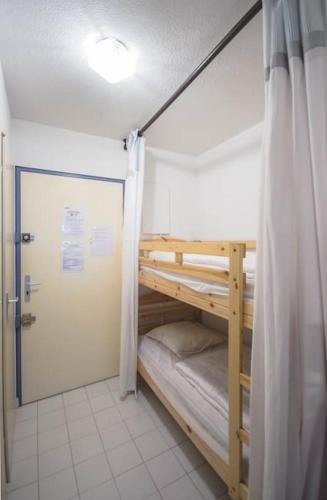 Cette chambre comprend 2 lits superposés et une porte. dans l'établissement Chez Adeline - Confortable appartement avec piscine et parking, à La Grande Motte