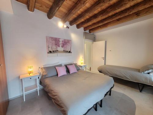 a bedroom with a bed and two tables with pink pillows at Angelo&Marì Mountain Lake Iseo Hospitality in Marone