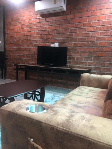 un soggiorno con divano e tavolo con TV di แครินโฮมสเตร์ a Koh Lone