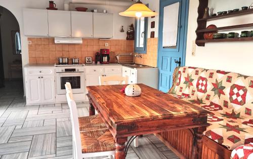 a kitchen with a wooden table and a couch at Elitas Lodge: Cosy Cycladic home outside Paroikia in Kampos Paros