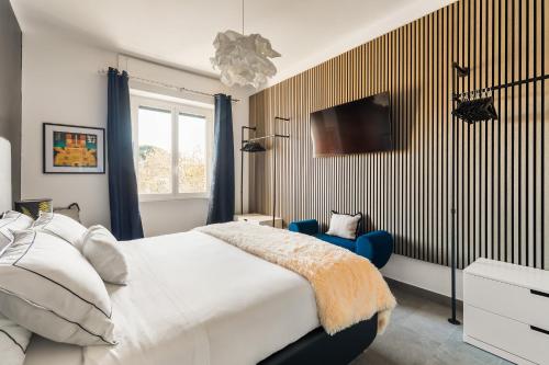 a bedroom with a bed and a tv on the wall at Cozy apartment Gianicolense 3bdr in Rome