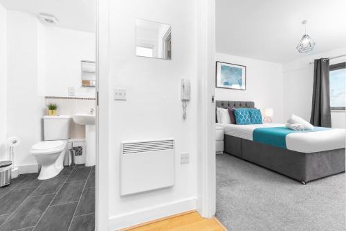 um quarto branco com uma cama e uma casa de banho em Birmingham City Centre Apartment - Digbeth 1 - Juliet Balcony - Free Netflix & Wifi - 19A em Birmingham