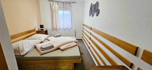 a small bedroom with two beds and a window at Penzion u Marešů in Hřensko