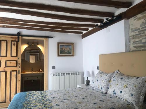 a bedroom with a bed and a bathroom with a sink at Hotel Rural El Rincón de Marta in Yanguas