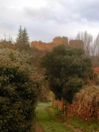 a path with a castle in the background at Hotel Rural El Rincón de Marta in Yanguas