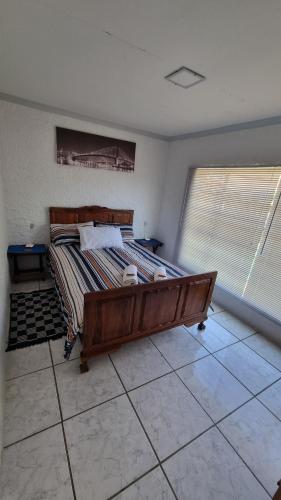 a bedroom with a large bed in a room with two windows at Ani-Lem Self-Catering in Ficksburg