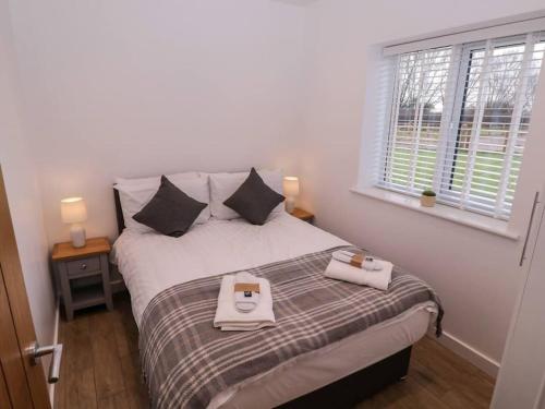 ein Schlafzimmer mit einem Bett mit zwei Tabletts drauf in der Unterkunft Walnut Lodge in Ashbourne