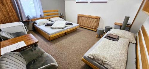 a small room with two beds and a couch at Penzion u Marešů in Hřensko