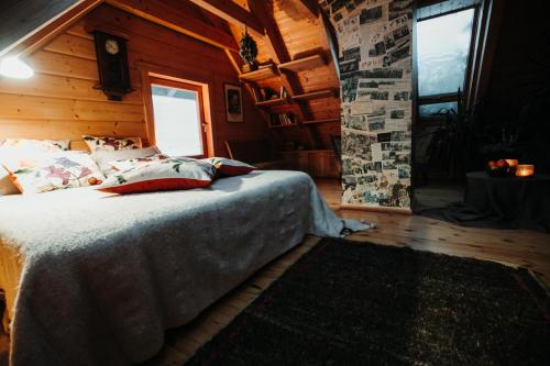 a bedroom with a bed in a log cabin at Hortus Paradisum in Ikšķile