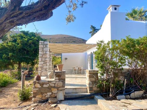 a small white house with a stone wall at Elitas Lodge: Cosy Cycladic home outside Paroikia in Kampos Paros