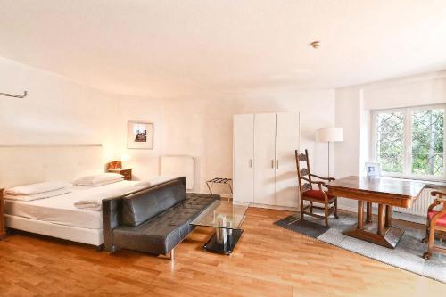 a bedroom with a bed and a desk and a table at Villa Verdi Apartments in Merano
