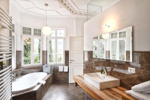 a bathroom with a large sink and a tub and a tubermott at Villa Verdi Apartments in Merano