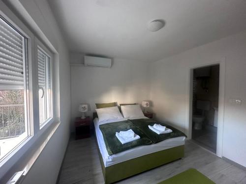 a bedroom with a bed in a room with a window at Cuprija _apartments in Stolac