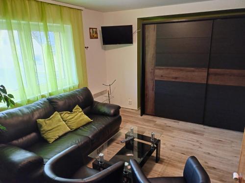 庫博娃霍特的住宿－Penzion Pod Boubínem，客厅设有真皮沙发和大型推拉门
