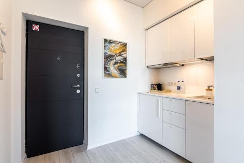 una porta nera in una cucina con mobili bianchi di Kaunas apartments near Bus station a Kaunas