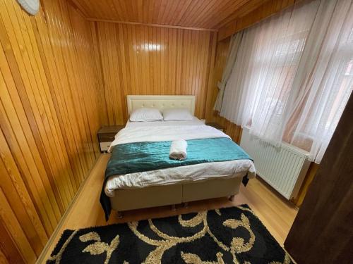 a bedroom with a bed in a wooden room at Uzungöl Bikka Pansiyon in Uzungöl