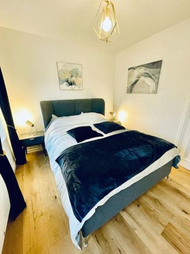 une chambre avec un grand lit avec une couverture bleue dans l'établissement Jolie maison centre historique, à Honfleur