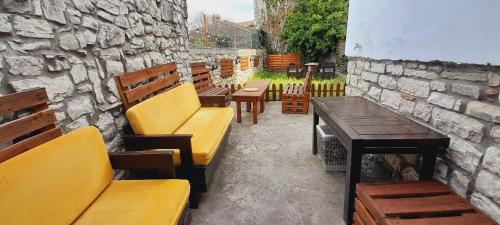 een patio met banken en tafels en een stenen muur bij Villa Maria - Berat Castle in Berat